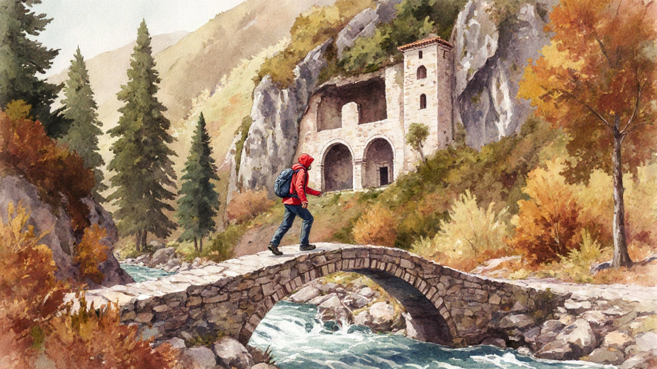 Senderista cruzando puente de piedra en la Ruta del Cister junto a un monasterio rupestre.