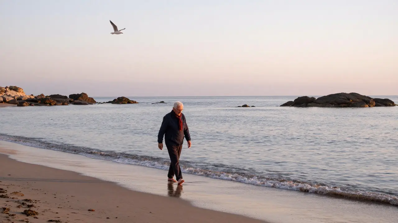 Persona caminando solo por la playa en octubre, con el mar fresco y el cielo suave al amanecer.